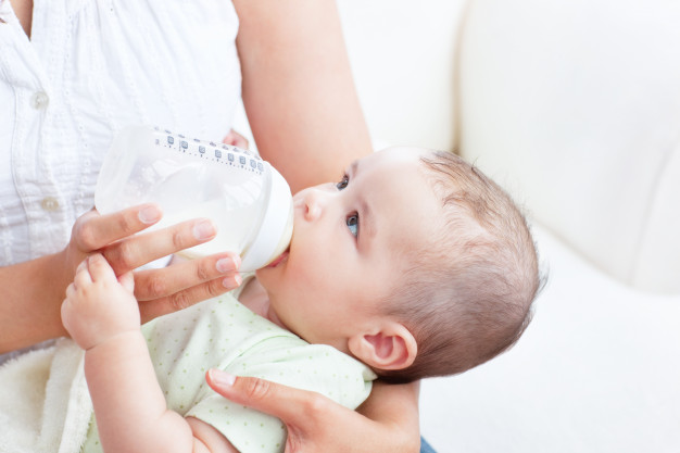 peaceful-baby-boy-lying-in-his-mother-s-arms-drinking-milk-for-lunch_13339-259503