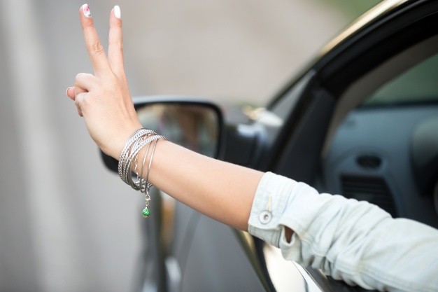 girl-driving-and-showing-the-victory-gesture_1163-850